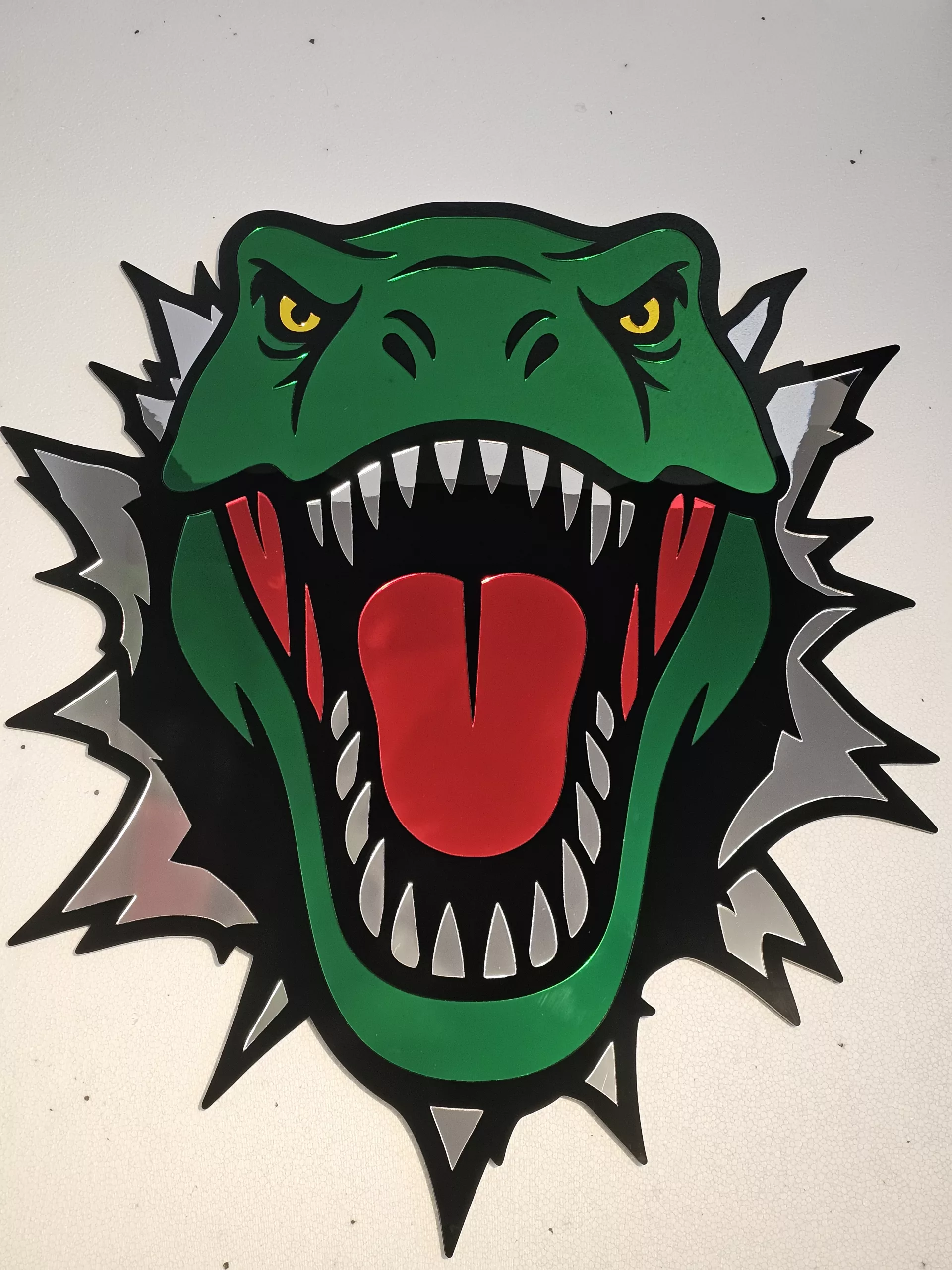 Coloured mirrored acrylic wall art in the shape of a T-Rex dinosaur