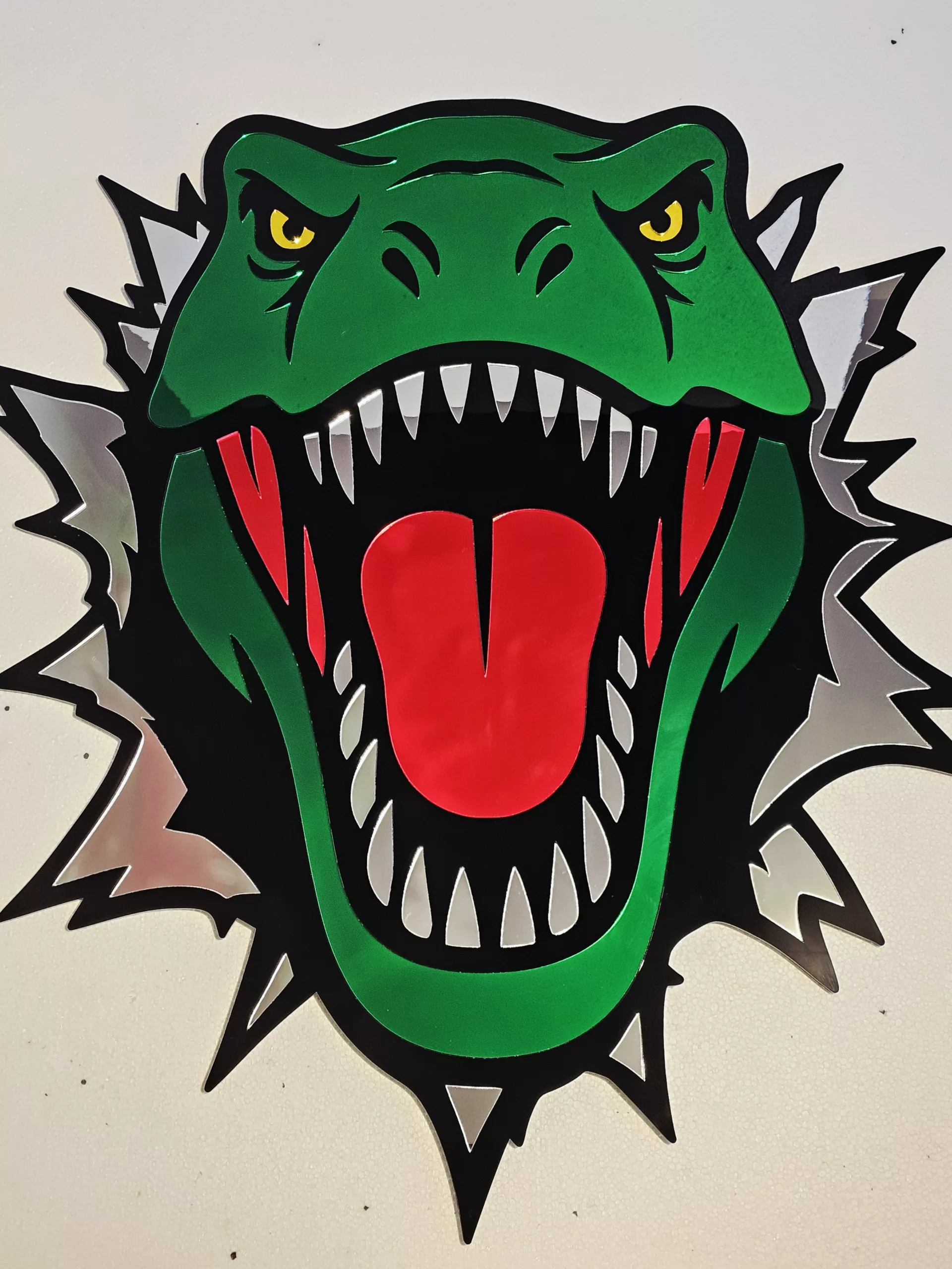 Coloured mirrored acrylic wall art in the shape of a T-Rex dinosaur