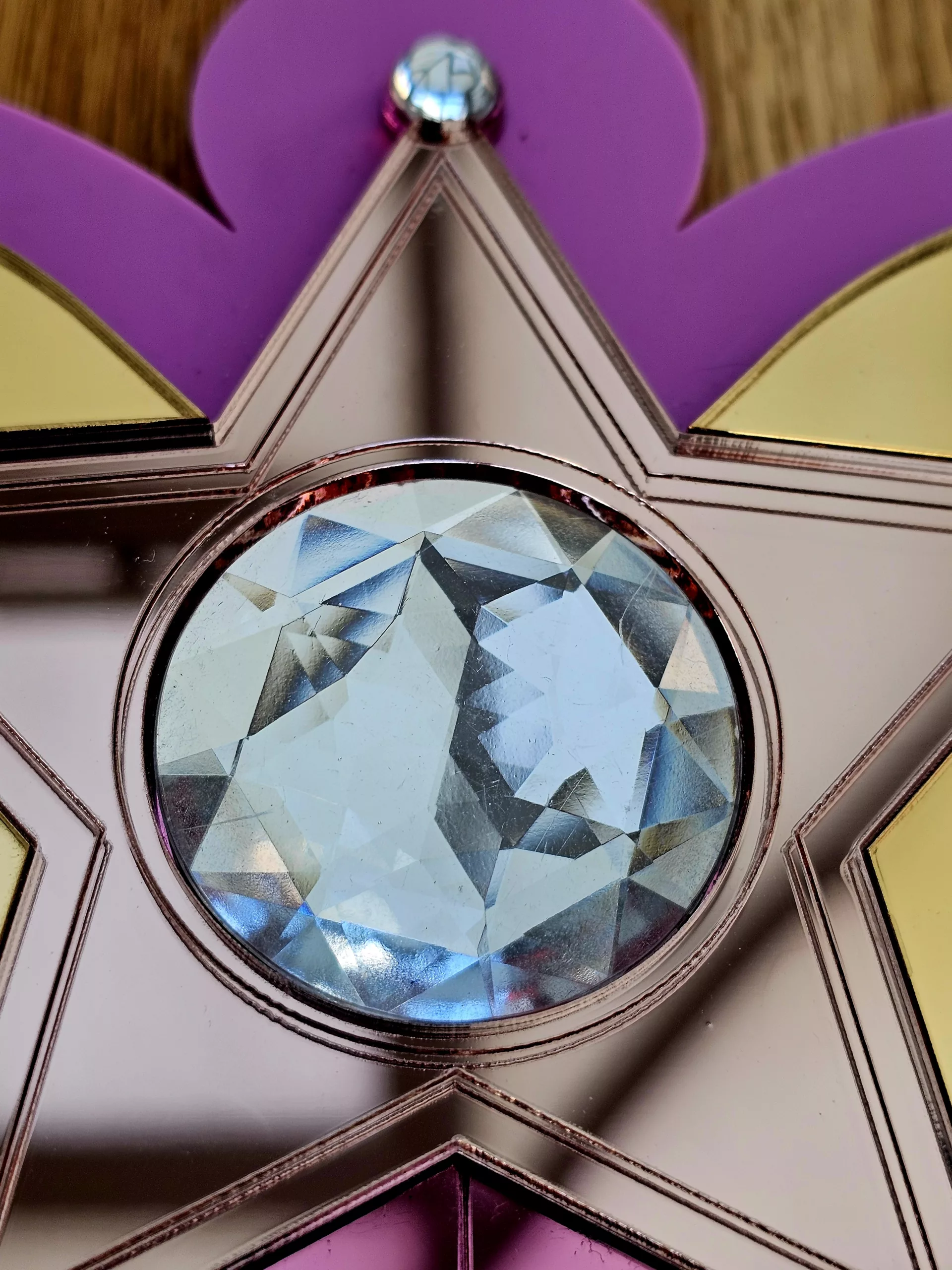 Details of a pink heart mirror, including a rose gold star inlaid with clear crystal.