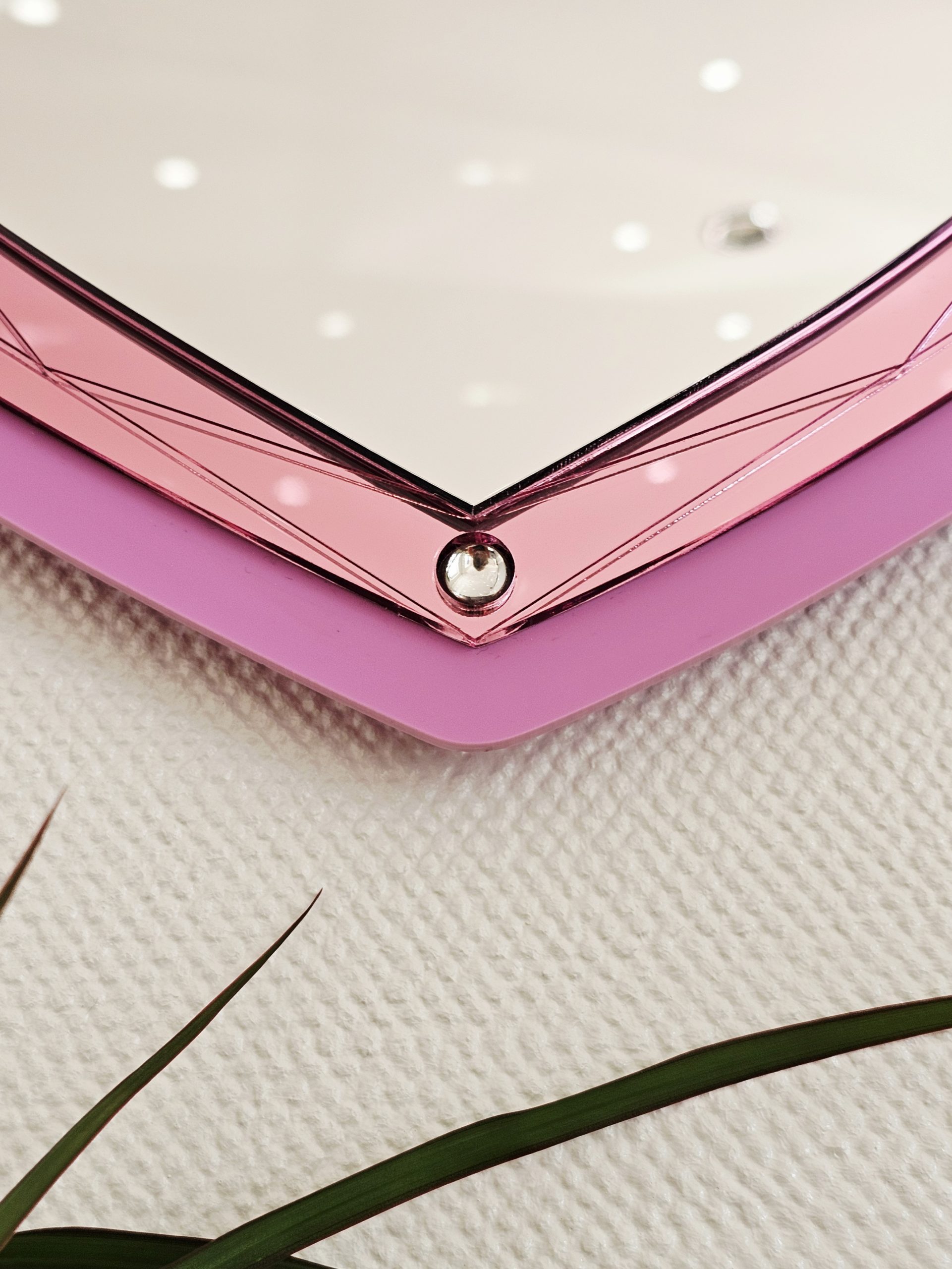 A heart mirror. Woth pink frame, layered with pink and silver heart, with details including gold wings inlaid with crystals.